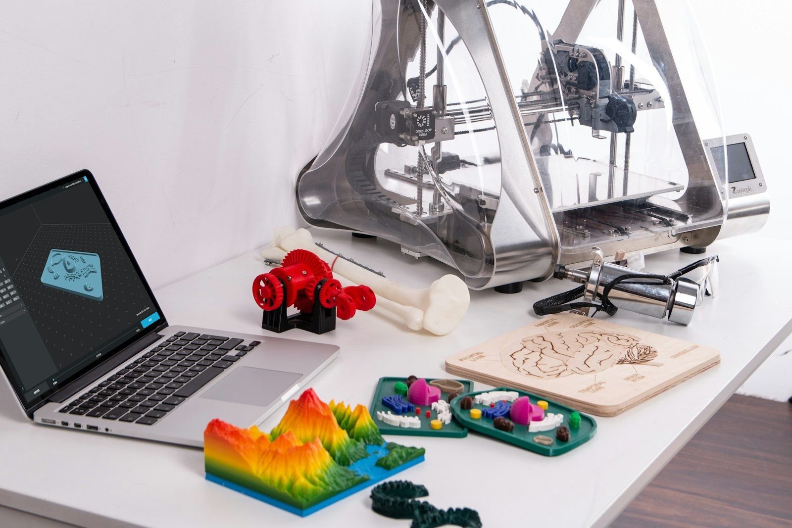 Ordinateur portable affichant un modèle 3D à côté d'objets imprimés