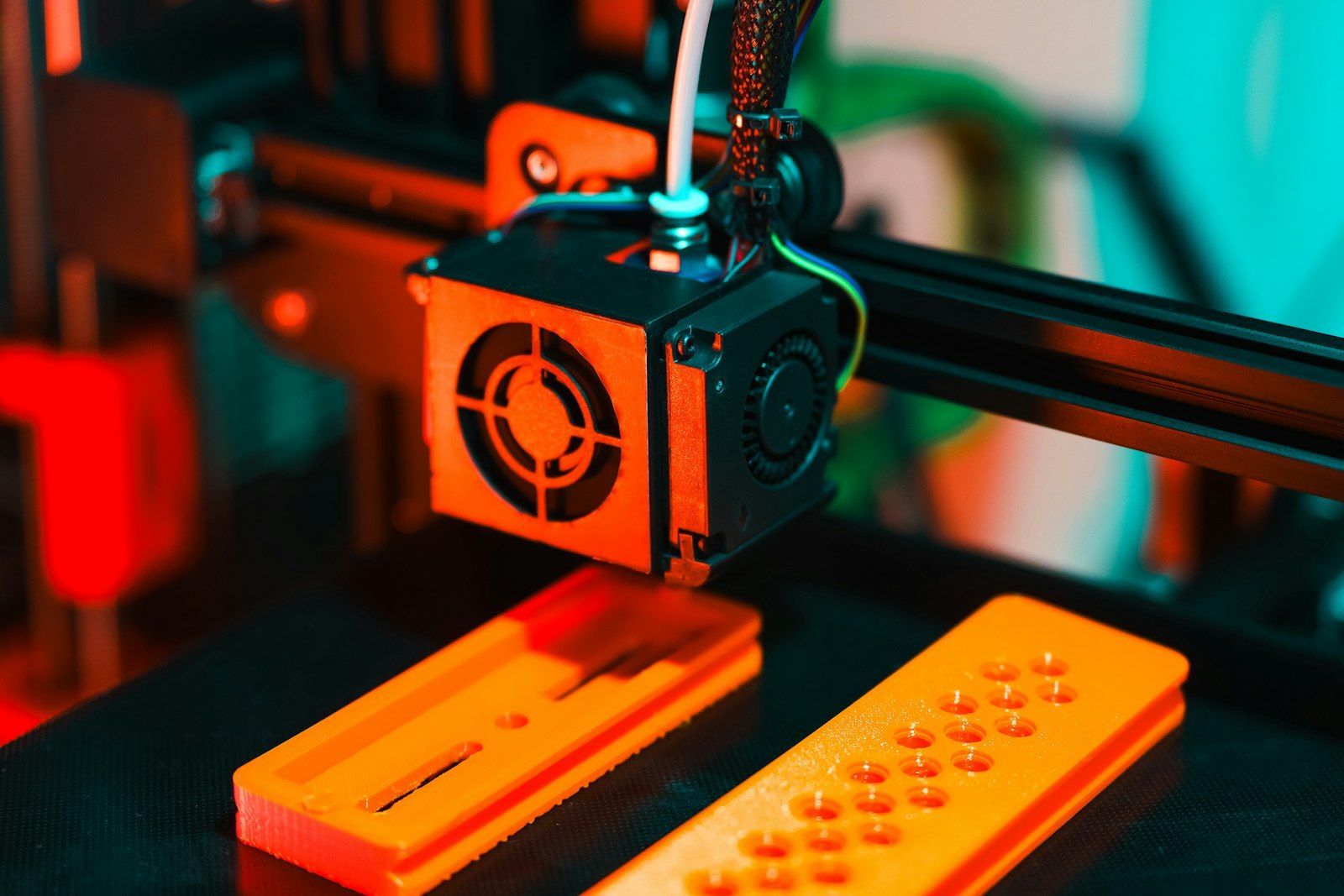 Pièces prototypes orange sur le plateau d'une imprimante
